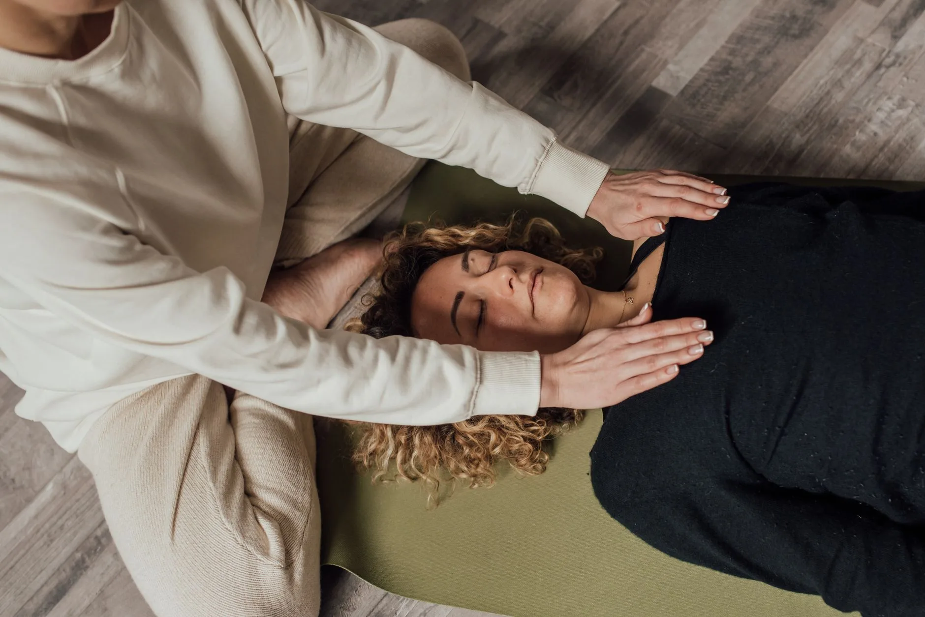 A practitioner holding their hands over a guest during a Reiki energy healing session